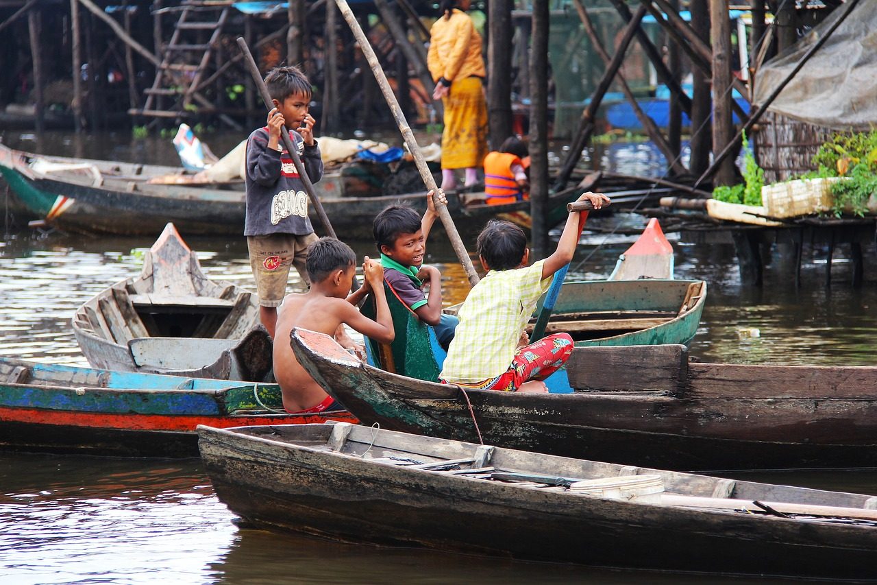 Children of the Tonle Sap floating village going about their daily life in wooden boats