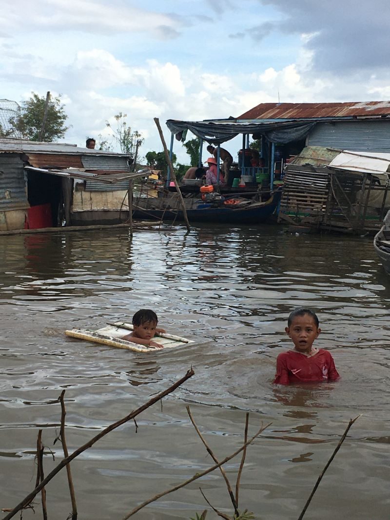Children swimming in the waters of the Tonle Sap floating village — captured during an early IHM mission