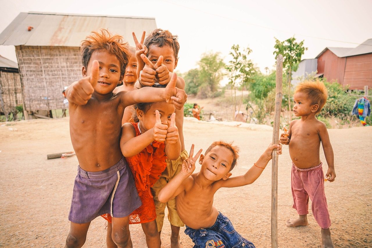 Cambodian children giving thumbs up — joyful, hopeful, empowered
