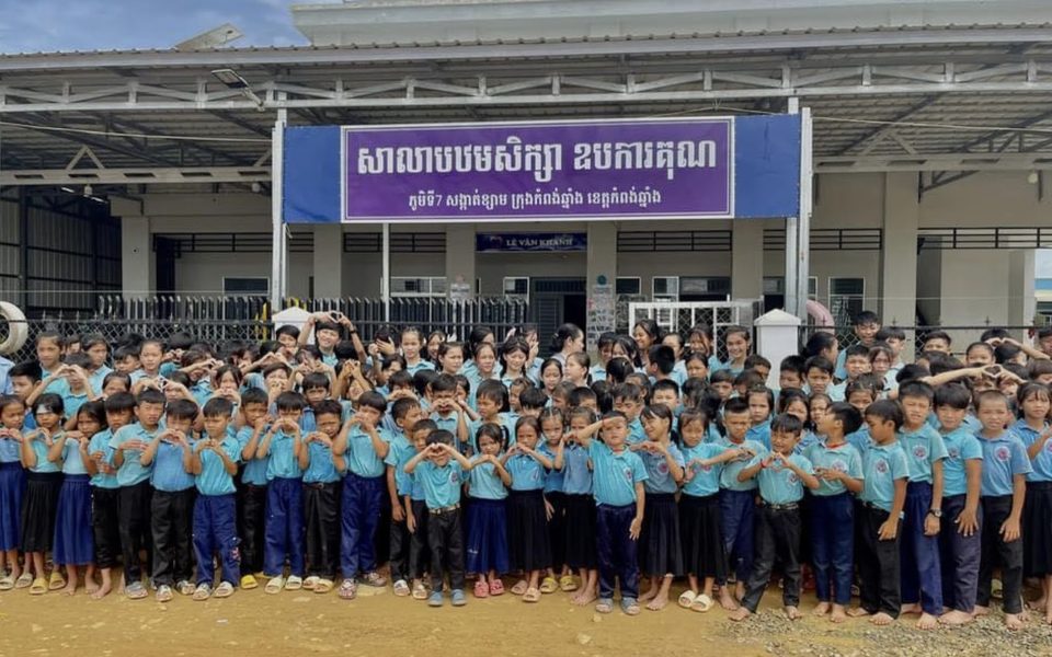 Students at the completed IHM school in Kampong Chhnang, Cambodia — making heart signs with their hands