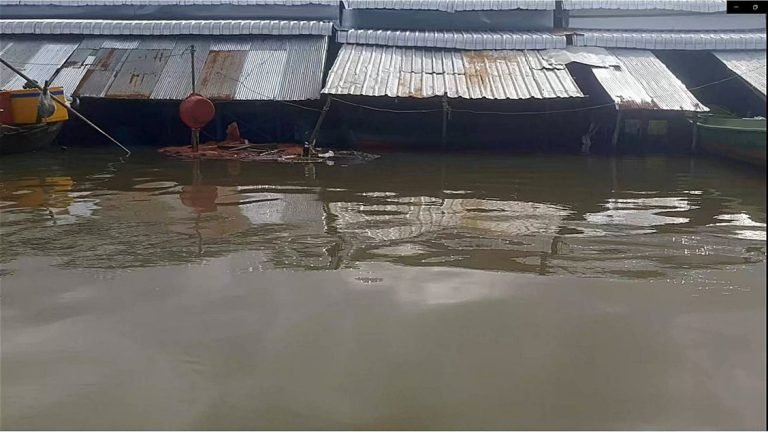 Close-up of flooded floating houses during monsoon season in Tri An